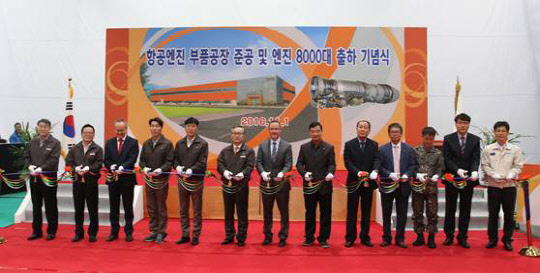 신현우 한화테크윈 대표(왼쪽에서 여섯번째)와 브라이언 요더 GE 구매이사 (왼쪽에서 일곱번째) 등 참석자들이 1일 창원 2사업장에서 항공 엔진 부품 공장 준공과 엔진 8000대 출하기념식 테이프 커팅식을 갖고 있다. 한화테크윈 제공